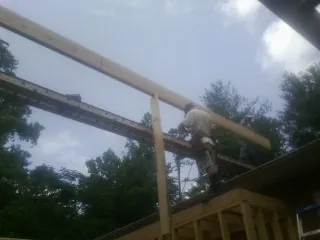 Carpenter setting a ridge beam over a new addition frame — Ice Dam Removal by Roofing Brothers in Kentwood
