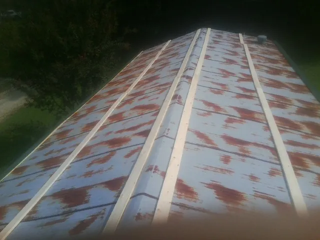 Rusted metal roof panels with new wood purlins before replacement — Storm Damage Roof Repair in Kentwood by Roofing Brothers